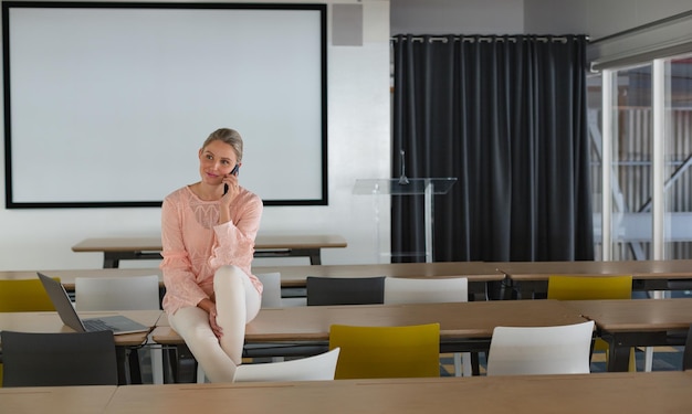 Une femme dirigeante parle au téléphone portable dans la salle de conférence.