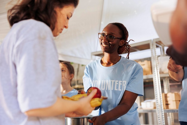 Une femme distribue des repas aux pauvres.