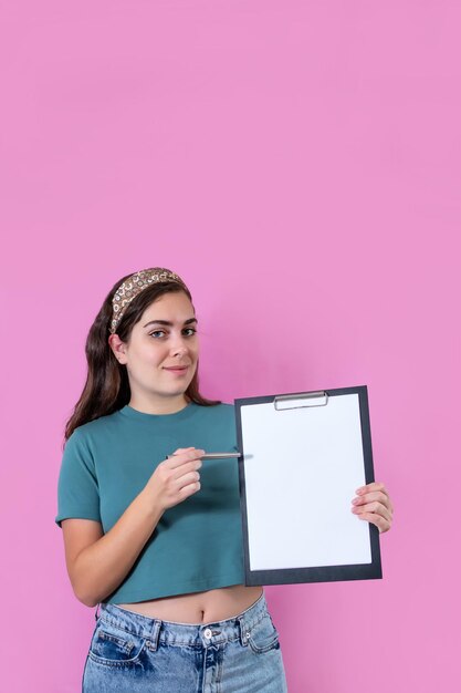 Femme avec document vide sur presse-papiers fond rose