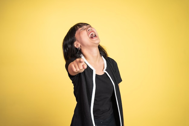 Femme avec le doigt pointé sur frong et riant de quelque chose