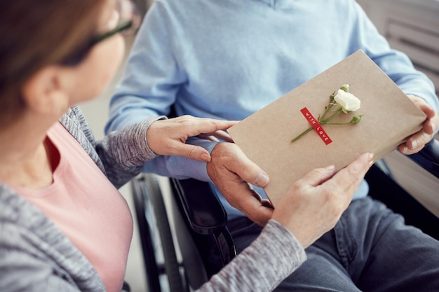 Femme donnant le cadeau de la Saint-Valentin fait avec amour à son mari