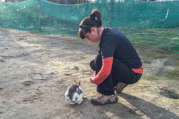 La femme donne de la nourriture au lapin. Amour de la nature et concept végétalien