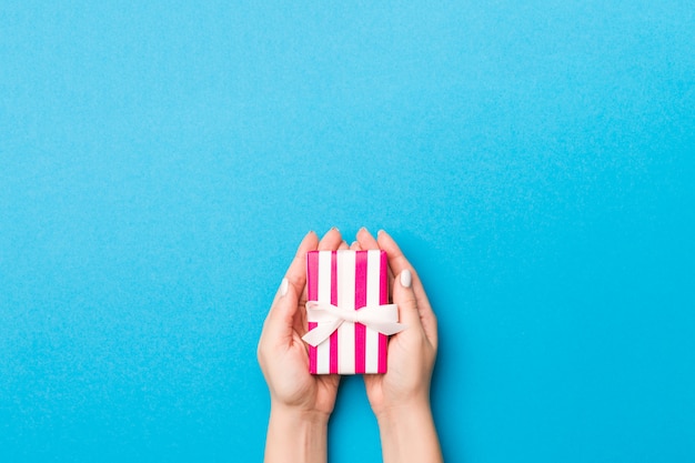 Femme donne une petite boîte cadeau Saint-Valentin avec un arc blanc