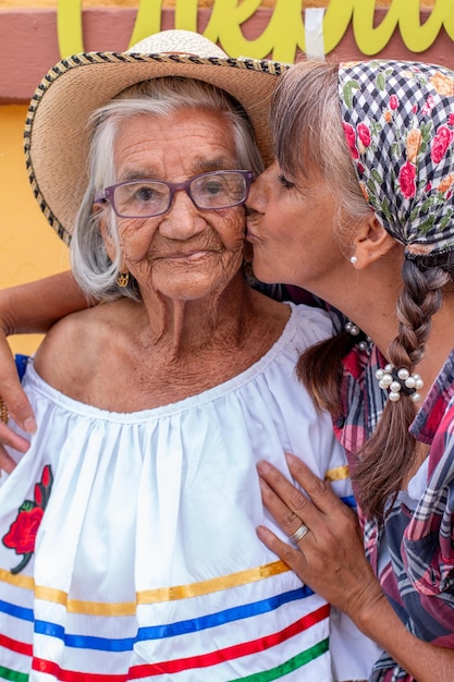 Femme donne un tendre baiser sur la joue à sa mère de 95 ans Portrait de mère et fille