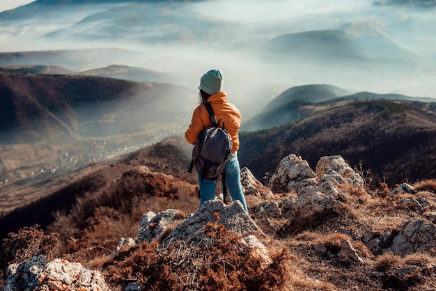 Une femme dont les randonneurs profitent d'une pause regarde le sommet de la montagne