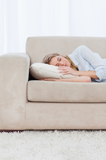 Une femme dort sur un canapé