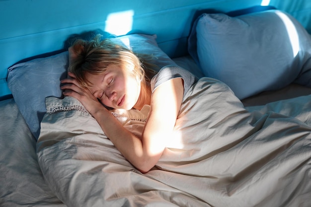 Une femme dort sur un lit au soleil