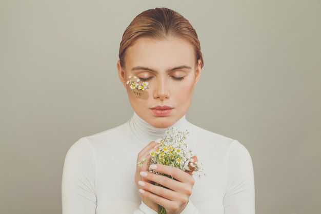 Femme douce avec des fleurs et une inscription d'espoir sur du plâtre adhésif sur fond blanc portrait