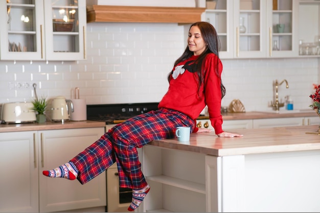 Une femme douce et satisfaite le matin dans la cuisine à la maison s'étire et est de bonne humeur