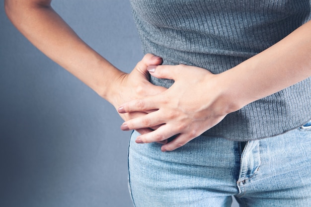 La femme a une douleur dans le côté de l'abdomen