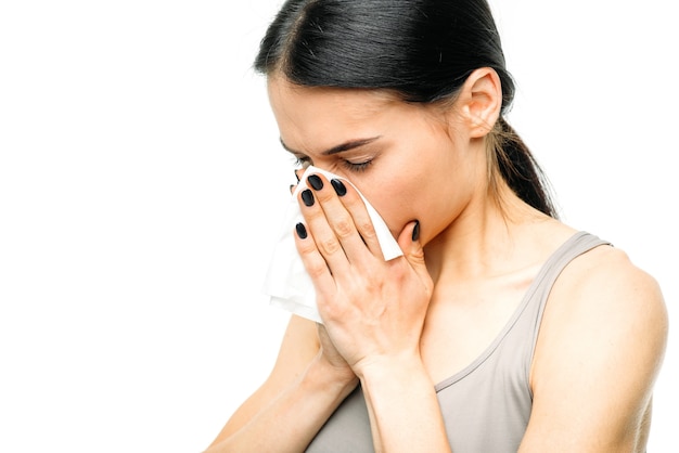 Femme douloureuse avec nez qui coule, morve ou grippe sur blanc.