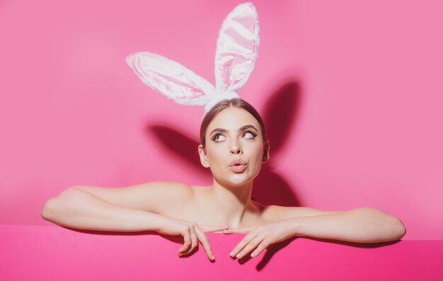 Femme drôle de Pâques avec des oreilles de lapin portrait d'une jolie jolie fille isolée sur la bannière rose copie sp
