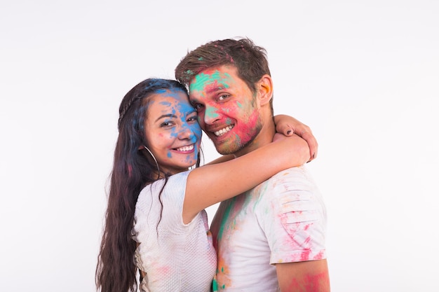 femme drôle souriante et homme posant avec de la poudre multicolore sur leur