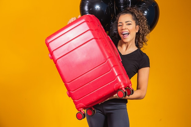 Femme drôle tenant un sac de voyage lourd. Anniversaire de promotion de voyage. Black Friday sur les billets de voyage.