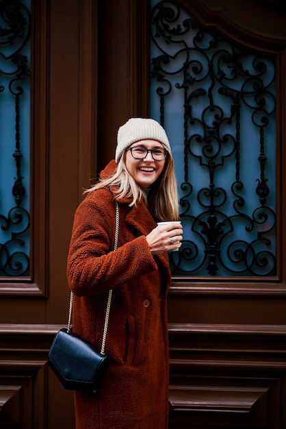 Femme avec du café près de la porte