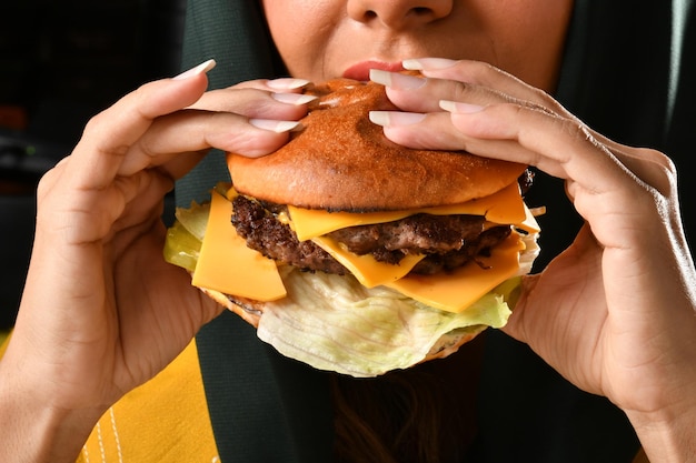 Photo une femme du golfe saoudien mangeant un délicieux sandwich au burger un délicieux burger au poulet croustillant rapidement