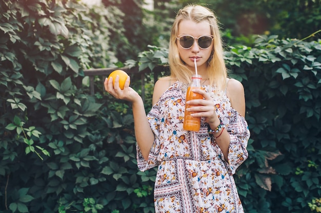 Femme avec du jus de boisson orange