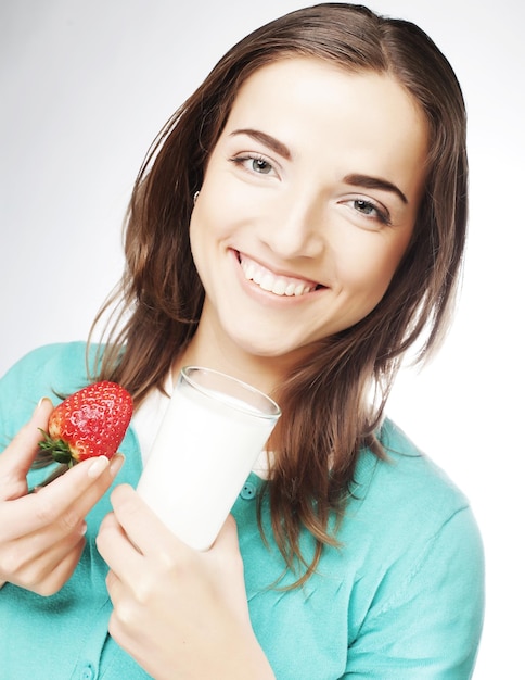 Femme avec du lait et des fraises