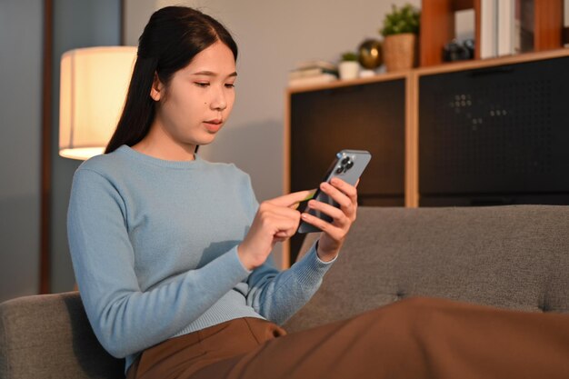 Femme du millénaire vérifiant les médias sociaux ou discutant avec des amis sur son téléphone portable Technologie des gens et concept de style de vie