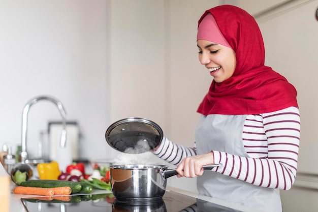 Femme du Moyen-Orient portant le hijab cuisinant à la maison copie espace