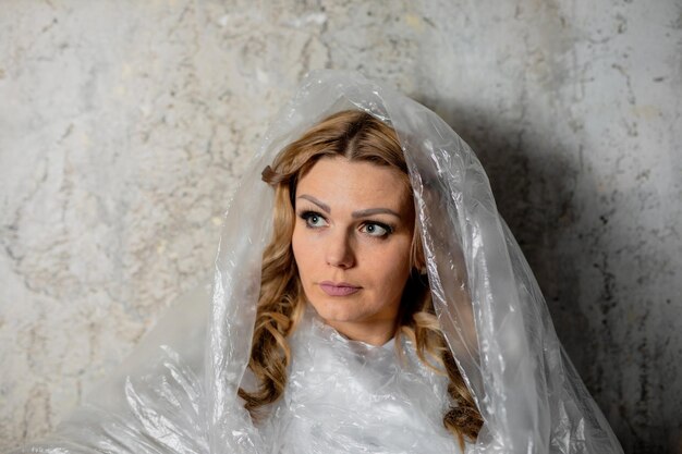 Photo femme avec du plastique contre le mur