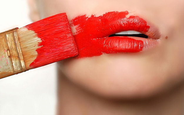 Photo une femme avec du rouge à lèvres se brosse les dents