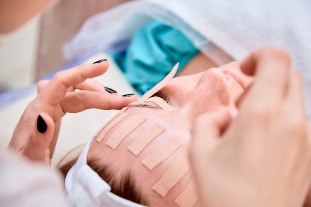 Femme avec du ruban de kinésiologie sur le visage