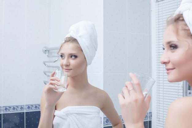 Femme avec du verre dans la salle de bain