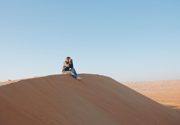 Photo une femme sur une dune de sable