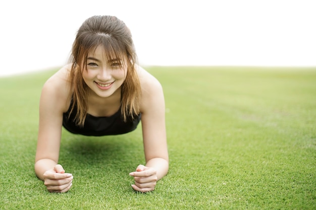 femme échauffement et faire quelques push ups ou planking sur le terrain de gazon