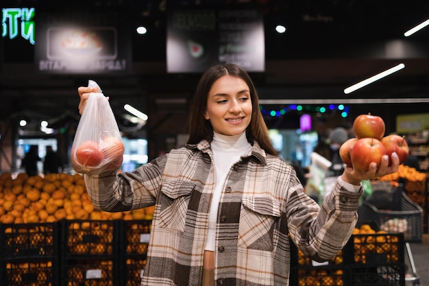 Une femme écologique achète des pommes au supermarché