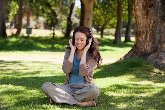 Femme écoutant de la musique dans le jardin