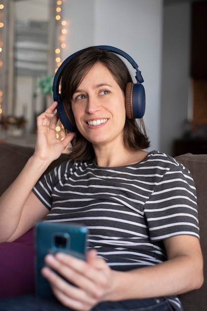 Femme écoutant de la musique avec des écouteurs avec un téléphone mobile