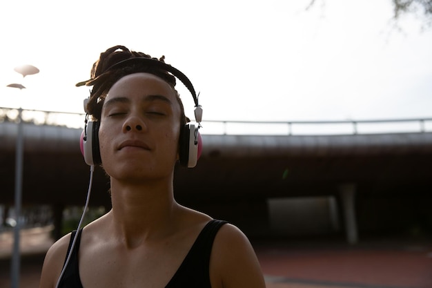 Photo femme écoutant de la musique sur des écouteurs en ville