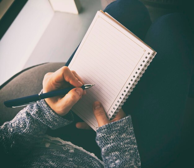 La femme écrit dans le cahier en papier