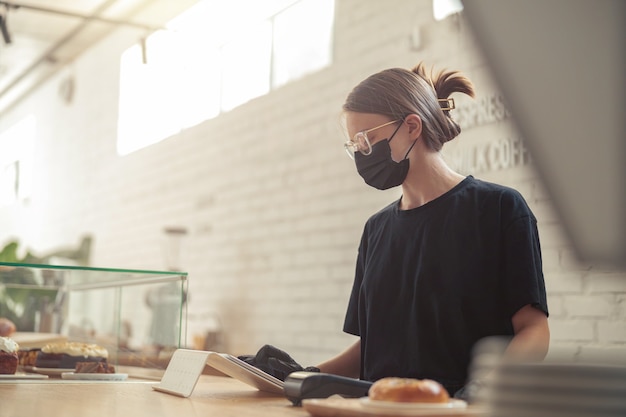 Femme écrivant dans l'ordre des clients sur tablette électronique