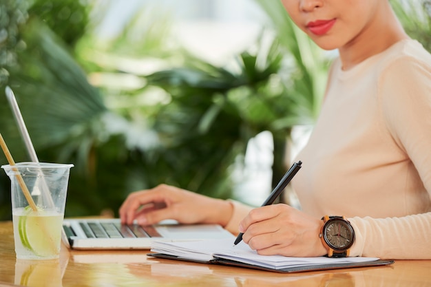 Femme écrivant des plans dans le bloc-notes