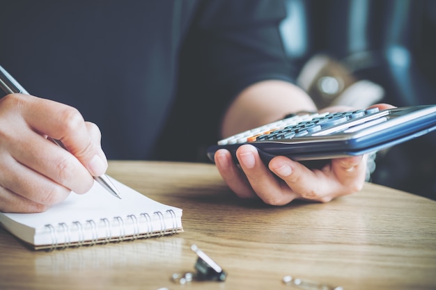 femme écrivant et utilisant la calculatrice