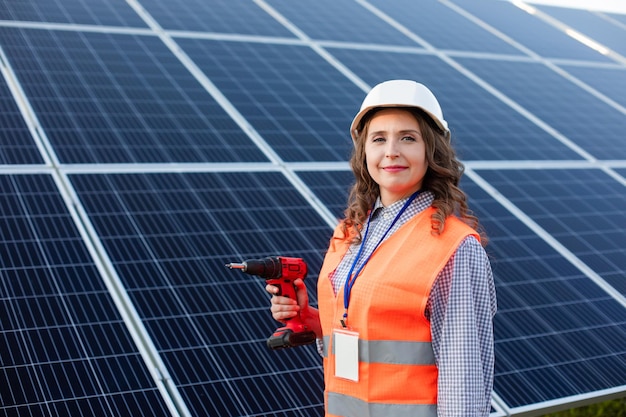 La femme électricienne avec tournevis à la station solaire