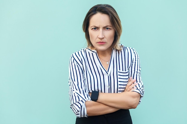 Femme élégante adulte belle agressive en colère regardant la caméra avec un visage en colère