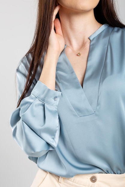 Une femme élégante en blouse bleue avec un décolleté plongeant