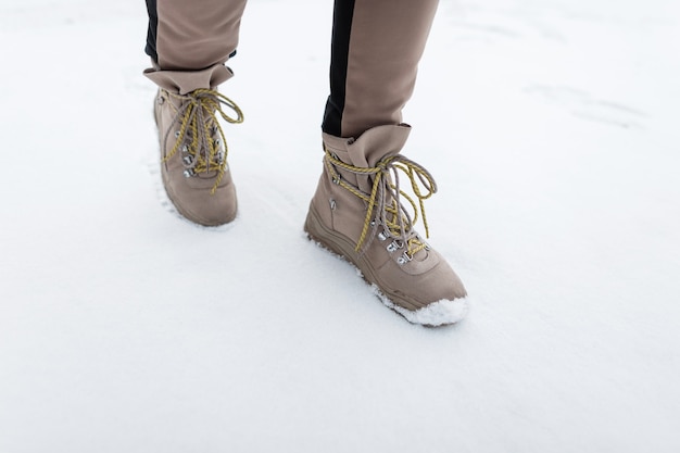 Femme élégante avec des bottes en cuir d'hiver à lacets jaunes. La fille porte des chaussures d'hiver chaudes et élégantes. Fermer.