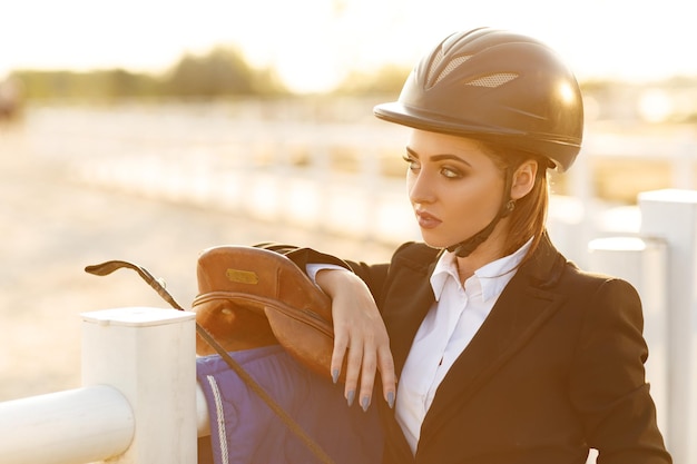 Femme élégante de cavalier dans le casque avec le fouet