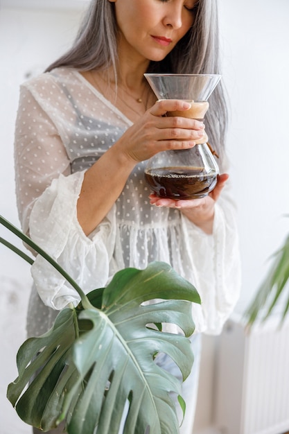 Femme élégante de cheveux pâles mûrs avec du café