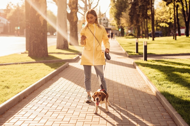 Femme élégante avec un chien à l'aide d'un smartphone