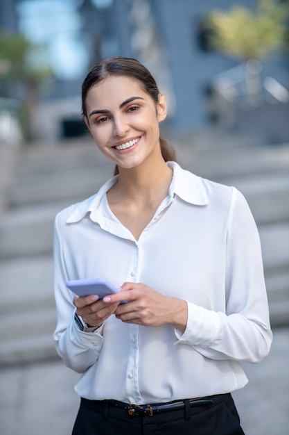 Femme élégante dans une chemise blanche se sentant satisfaite