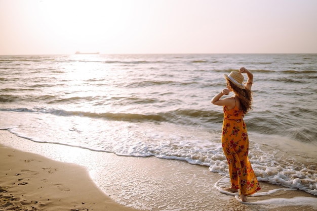 Une femme élégante dans une robe élégante posant près de la mer temps d'été Voyage week-end détente