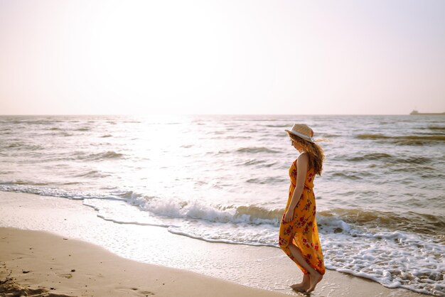 Une femme élégante dans une robe élégante posant près de la mer temps d'été Voyage week-end détente