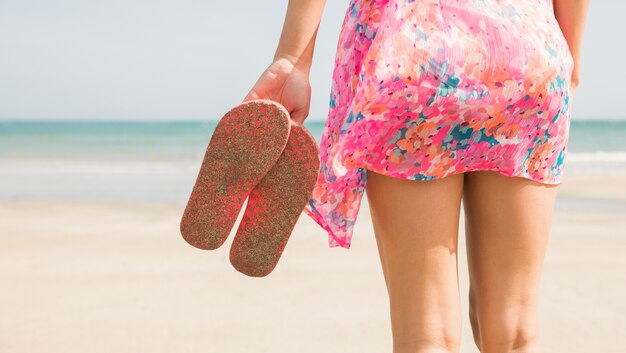 Femme élégante debout sur le sable