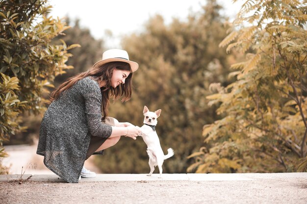 Femme élégante embrassant un chiot chihuahua à l'extérieur